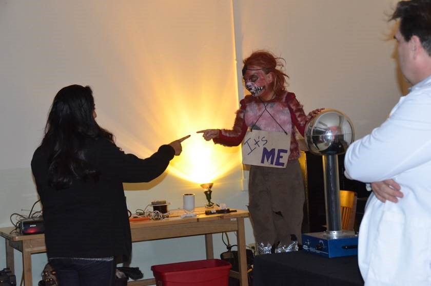 Girl in costume touches Van de Graaff generator