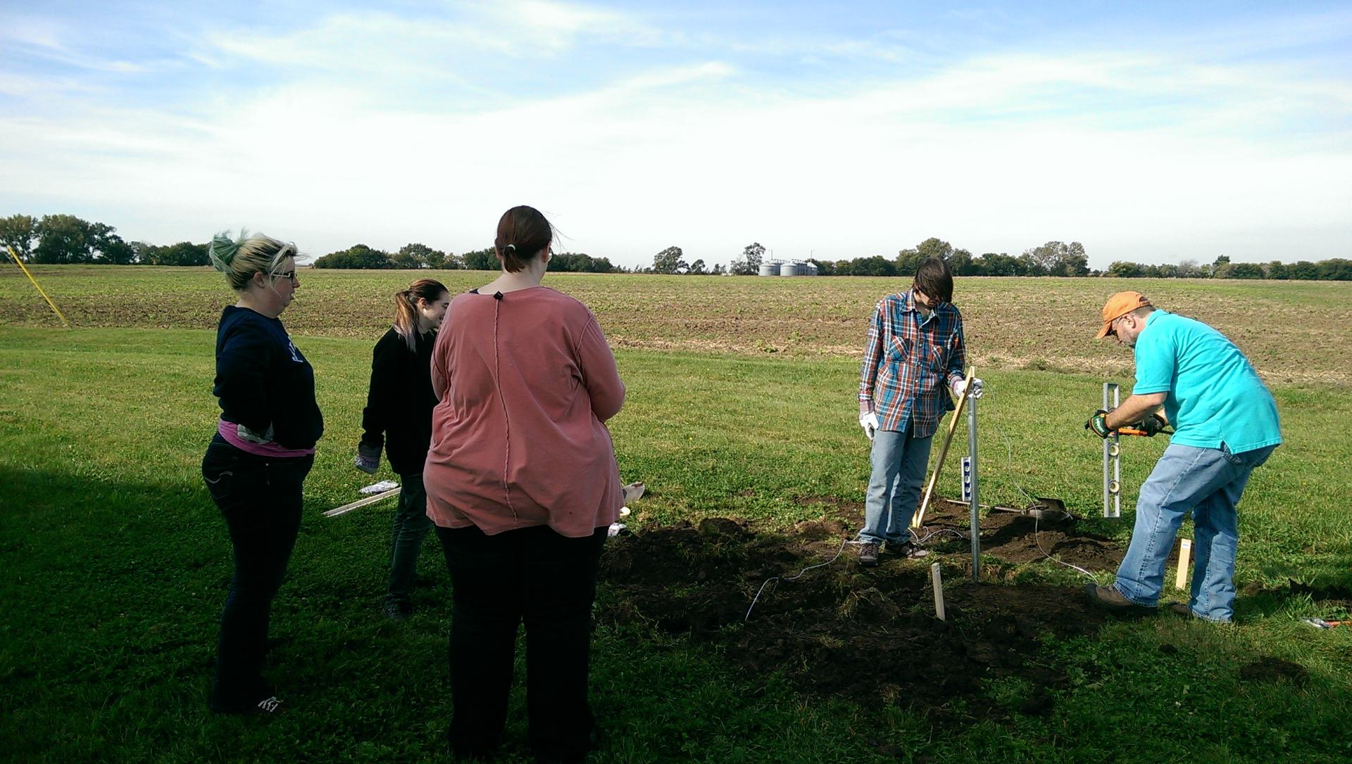 People digging a hole near Behlen Observatory to install a radio telescope array