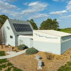 Image of Hyde Observatory showing the building and surrounding sidewalks and park.